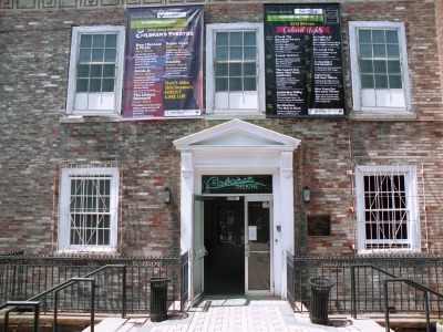 The red brick facade of 263 Golden Hill Street: a white classical portico over the entrance, tall sash windows, and season banners hung above the door