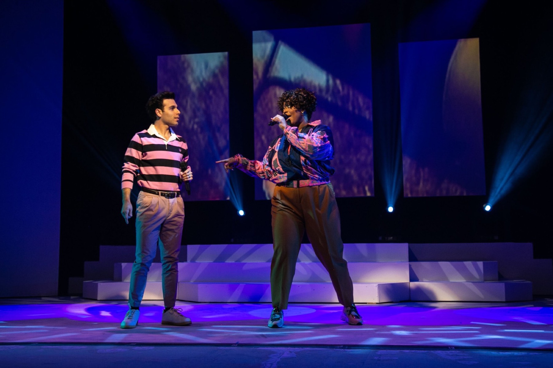 Two performers on the lit stage during a concert